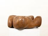 a wooden sculpture on a white pedestal with a white background