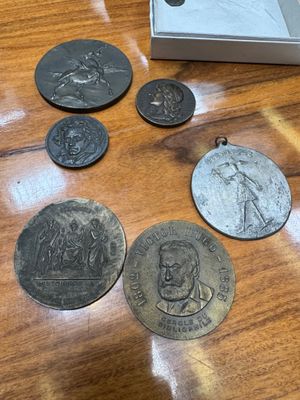 some old coins are sitting on a wooden table next to a box