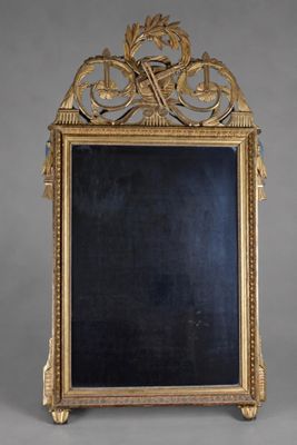 un miroir orné d'un cadre doré, avec un tableau noir au centre