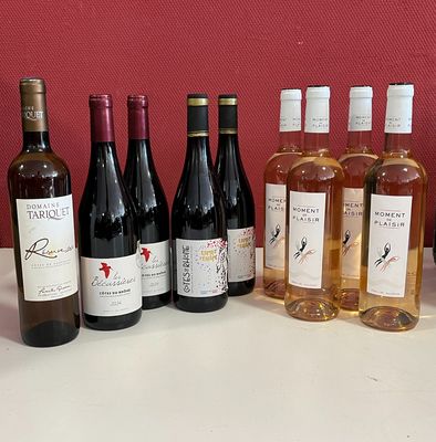 plusieurs bouteilles de vin posées sur une table à côté d'une caisse de vin
