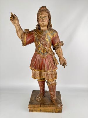 an old wooden statue of a man in a red outfit