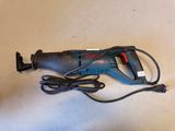 an image of a corded electric drill is laying on a table