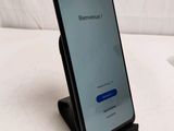 a close up of a cell phone on a stand on a bed