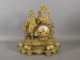 a gold clock that is sitting on top of a table
