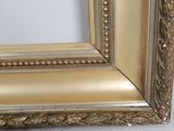 an image of a picture of a gold frame on a white wall