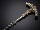 a silver bottle opener with a cork opener on a black background