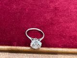 une bague en diamant posée sur un coussin en velours rouge