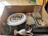 une boîte en carton remplie d'objets hétéroclites dans une pièce