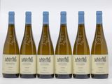 six bouteilles de vin blanc sont alignées