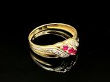 gros plan d'une bague en or avec une pierre en rubis