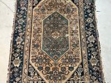 an old rug is laying on the floor in the middle of a room