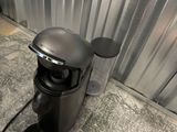 a coffee maker sitting on the floor next to a cup of coffee