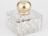 un gros plan d'un flacon de parfum en verre transparent muni d'un bouchon doré