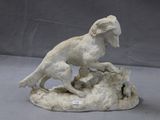 a statue of a dog that is on a rock