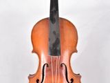 un vieux violon posé sur une surface blanche