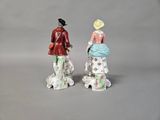 pair of figurines of a woman and a man with a dog