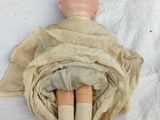 a doll that is laying on the ground with a scarf around it