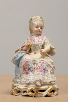 a figurine of a woman sitting on a table