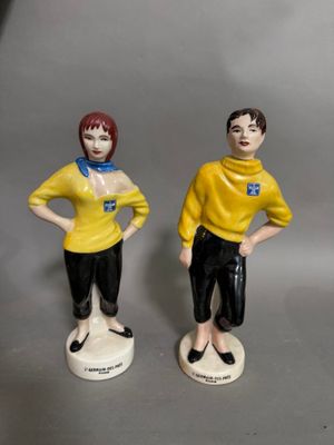 deux figurines d'un homme et d'une femme debout l'un à côté de l'autre