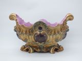 un bol violet et doré posé sur un fond blanc