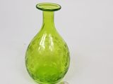 a green glass vase with a small glass object in it