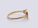 a close up of a gold ring on a white surface