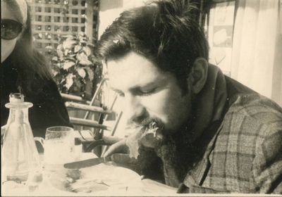 two people sitting at a table eating food together