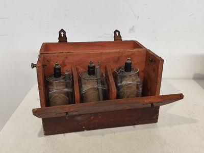une boîte en bois contenant quatre bouteilles, posée sur une table