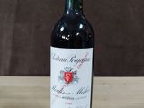 la bouteille de vin rouge est posée sur une table en bois