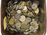 a lot of coins in a metal container on a table