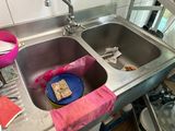 a blue plate in the sink with a piece of bread in it