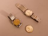 two watches and a watch sitting on a table next to each other