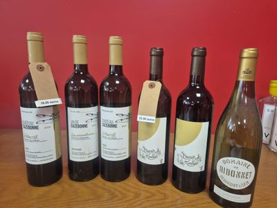 plusieurs bouteilles de vin sont alignées sur une table en bois