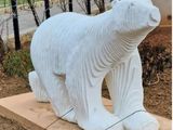 a statue of a polar bear sitting on a stone block