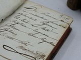 an old book with writing on it sitting on a table
