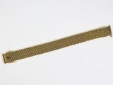 a close up of a gold bracelet on a white surface