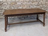 a wooden table sitting in front of a brick wall