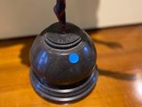 a black object with a blue dot on it on a wooden table