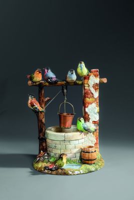 a figurine of a well with birds on it