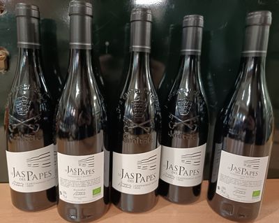 six bouteilles de vin rouge sont alignées sur une étagère