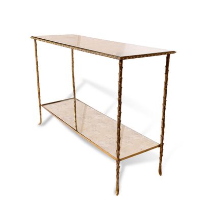 une console dorée avec un plateau en verre et des pieds en métal