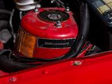 a close up of a red car engine with the hood open