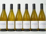 six bouteilles de vin blanc alignées sur une table