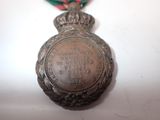 a silver medal with a ribbon around it on a table