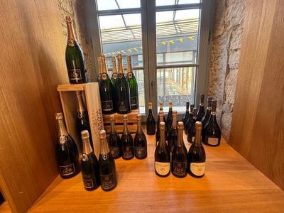 plusieurs bouteilles de vin posées sur une table devant une fenêtre