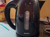 a black kettle sitting on a counter next to a jar of liquid