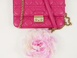 pink quilted purse with a pink flower on a white background