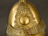 an antique helmet with a gold decoration on a stand