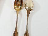 two spoons sitting next to each other on a table