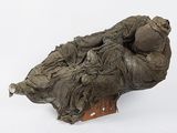 a sculpture of a woman laying on a piece of cloth